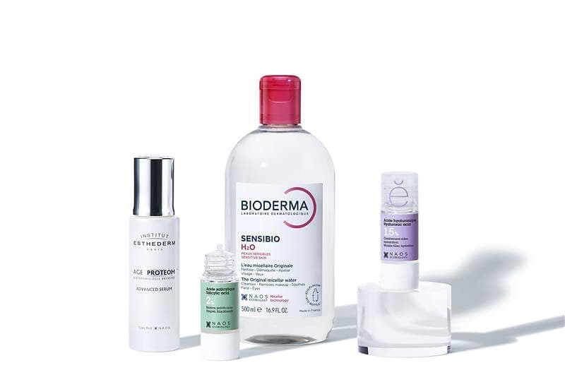 Naos brand best sellers: Bioderma Sensibio H2O micellar water, Institut Esthederm Age Proteom serum, and two Etat Pur treatments, salicylic acid and hyaluronic acid.